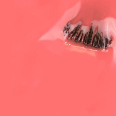 Escova de dentes com pasta de dentes branca em fundo rosa salmão
