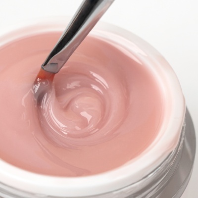 Frasco aberto de gel rosa translúcido com pincel