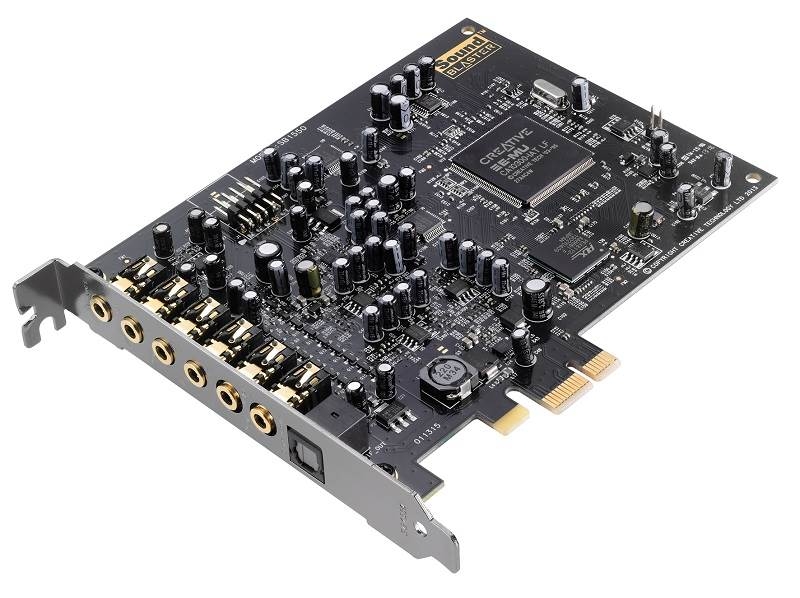 Placa de som preta com múltiplos componentes eletrónicos, conexões áudio douradas e texto Creative Sound Blaster