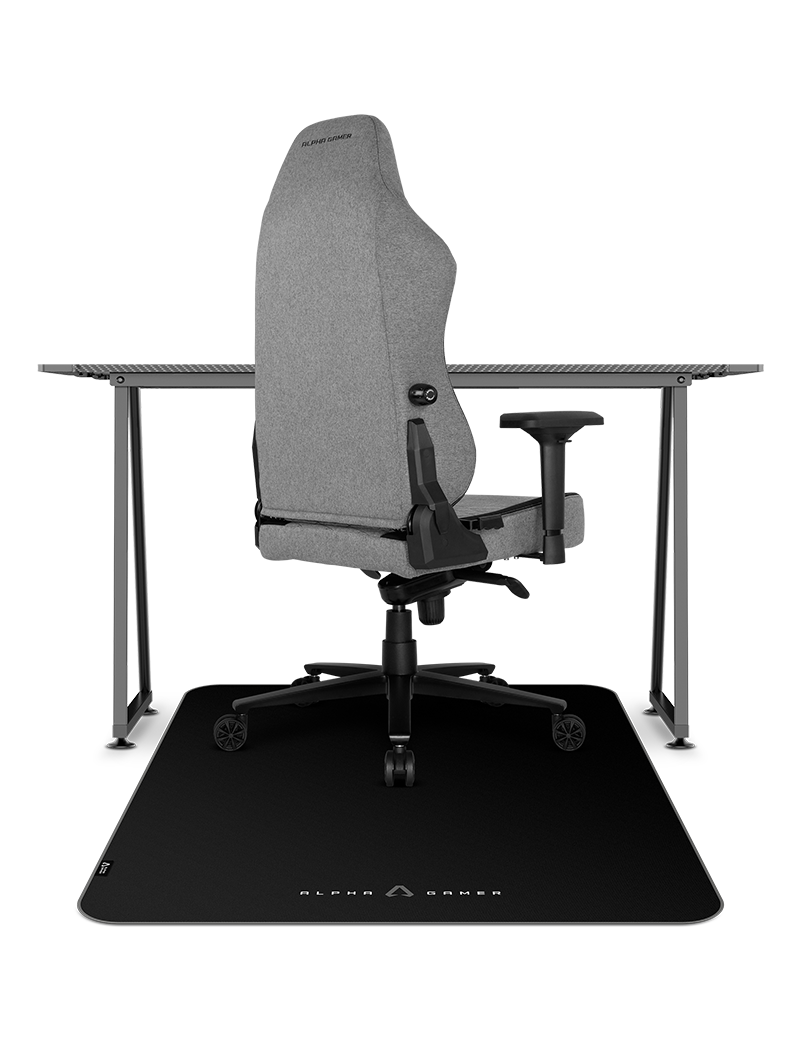 Cadeira gamer cinzenta sobre tapete preto com logo, junto a secretária