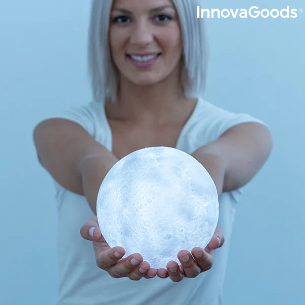 Mulher segurando luminária em forma de lua cheia iluminada