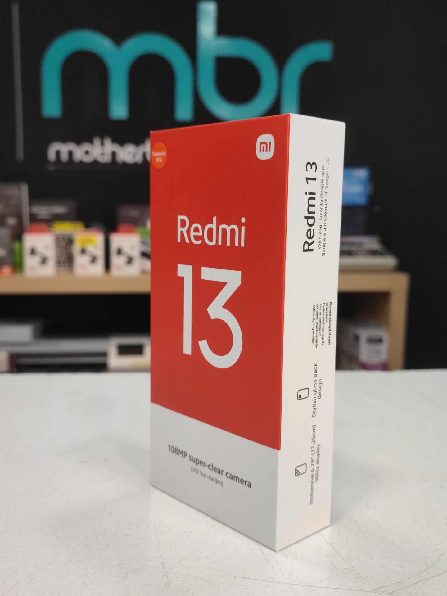 Caixa do smartphone Redmi 13 com texto em vermelho e branco