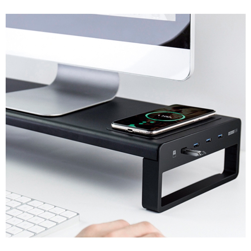 Suporte para monitor preto com smartphone a carregar ao lado e teclado branco