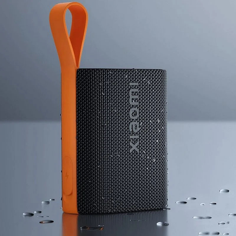 Coluna portátil Xiaomi preta com pega laranja em fundo azul
