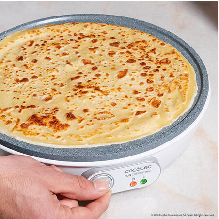 Crepière elétrica branca com plataforma cinza e crepe dourada sendo cozinhada