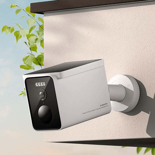 Câmara de segurança Xiaomi branca com frente preta montada numa parede bege