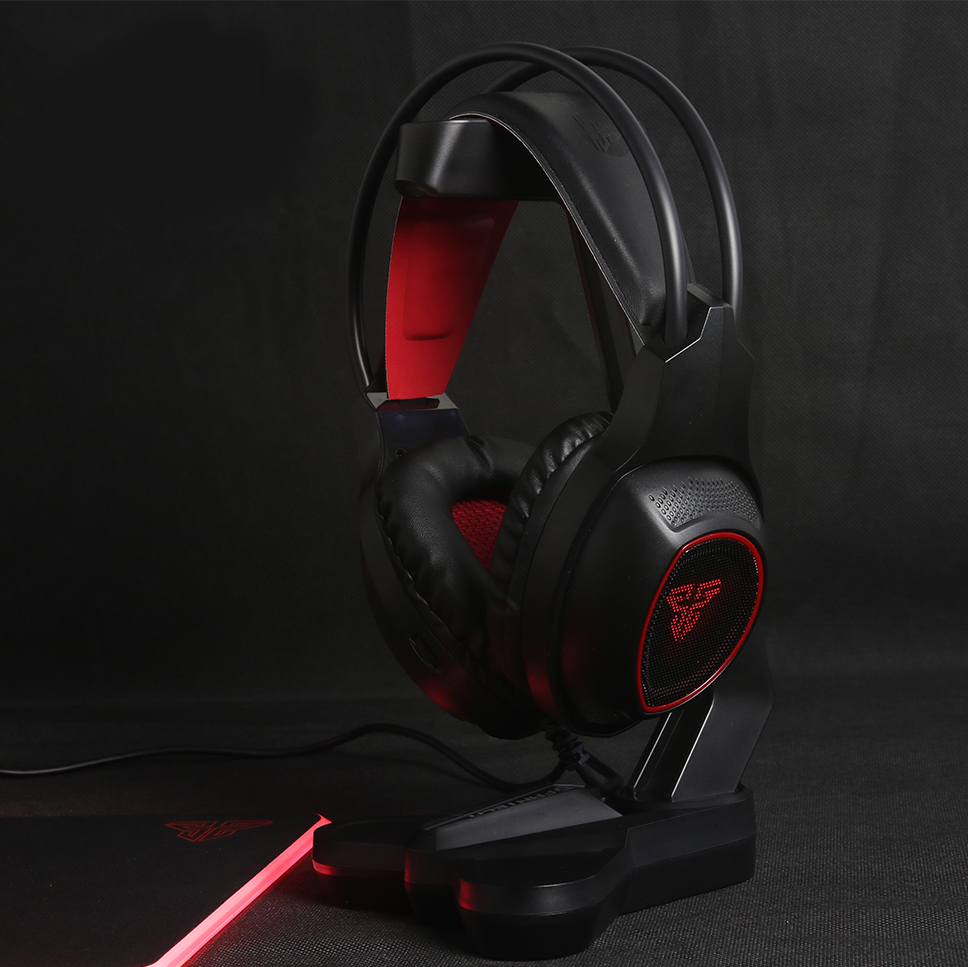 Auscultadores gaming pretos e vermelhos numa base preta