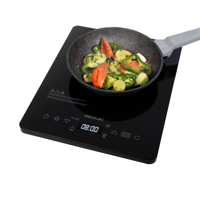 Placa de indução preta Cecotec com frigideira e vegetais frescos