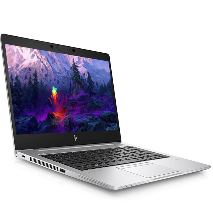 Computador portátil prateado HP aberto com ecrã a mostrar montanhas e lava colorida