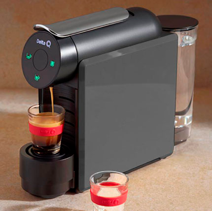 Máquina de café expresso Delta Q preta com duas chávenas pequenas em vidro e anel vermelho