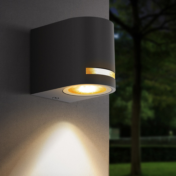 Arandela de parede exterior preta com luz amarela quente em parede clara