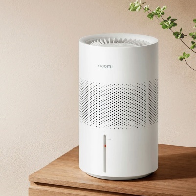 Humidificador branco da Xiaomi em superfície de madeira com planta ao lado