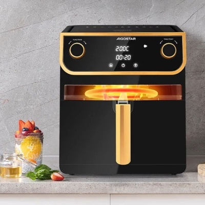 Fritadeira elétrica Aigostar preta com detalhes amarelos e visor digital em bancada de pedra cinzenta, com sobremesa ao lado