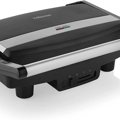 Aparato elétrico preto e prateado com alças largas e indicador de luz