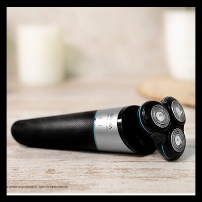 Barbeador elétrico preto com três cabeças circulares sobre superfície de madeira