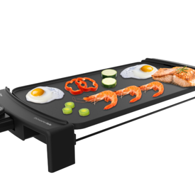 Grelhador elétrico com alimentos variados como ovos, pimento, curgete, camarões e salmão