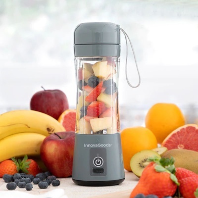 Liquidificador portátil cinzento InnovaGoods com frutas cortadas dentro e frutas frescas ao redor