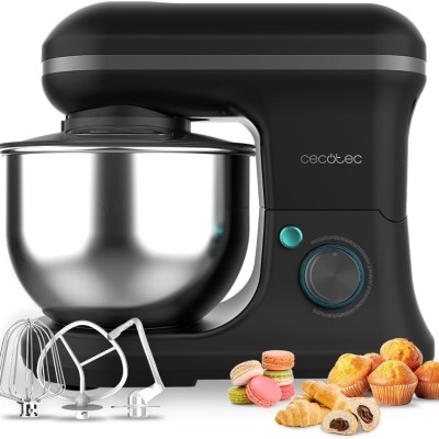 Máquina de mistura preta com taça metal e acessórios, rodeada por cupcakes, croissants e macarons