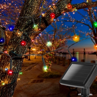 Luzes LED multicoloridas com painel solar instaladas em árvores ao ar livre à noite