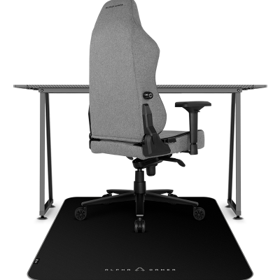 Cadeira gamer cinzenta sobre tapete preto com logo, junto a secretária