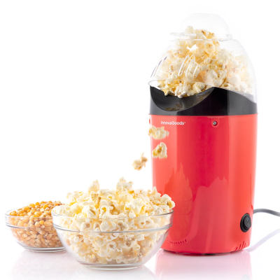 Máquina vermelha e preta de fazer pipocas com tampa transparente e taças em vidro com pipocas e milho cru