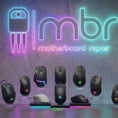 Muitos ratos de computador com iluminação RGB sobre balcão com fundo cinza e letreiro LED