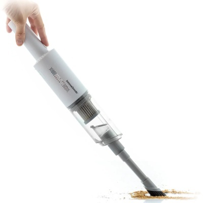 Aspirador de mão InnovaGoods branco a aspirar pó.