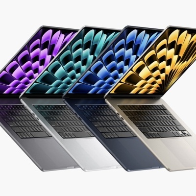 Quatro computadores portáteis de várias cores com ecrãs coloridos e teclados pretos