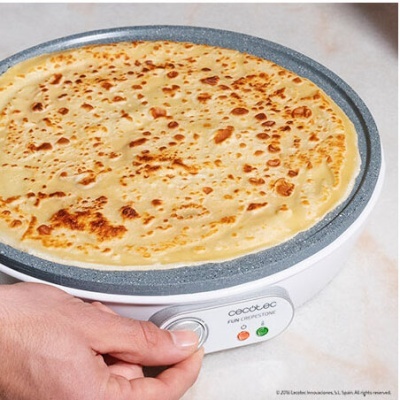 Crepière elétrica branca com plataforma cinza e crepe dourada sendo cozinhada