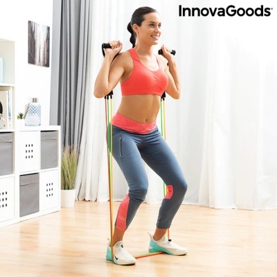 Mulher a usar roupa desportiva a fazer exercício com bandas elásticas coloridas em interior