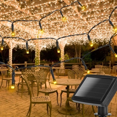 Cordão de luzes solares LED amarelas pendurado sobre terraço com cadeiras e mesas em metal