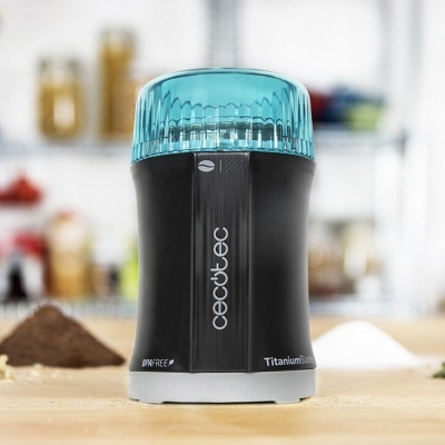 Moedor elétrico de café Cecotec preto com tampa azul em bancada de cozinha