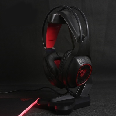 Auscultadores gaming pretos e vermelhos numa base preta