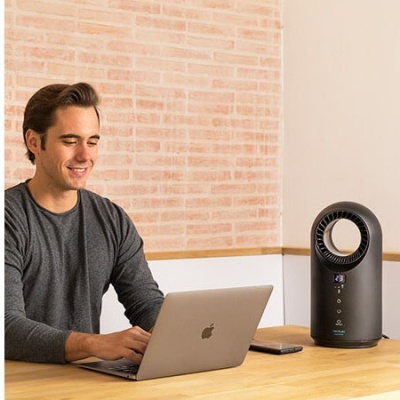 Homem a usar portátil Apple num ambiente com aparelho elétrico preto e parede de tijolos no fundo