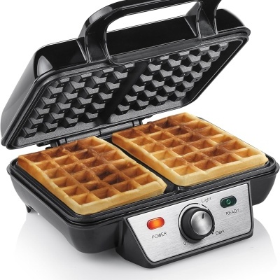 Máquina de waffles preta com waffles douradas e painel com botões e luzes indicadoras.