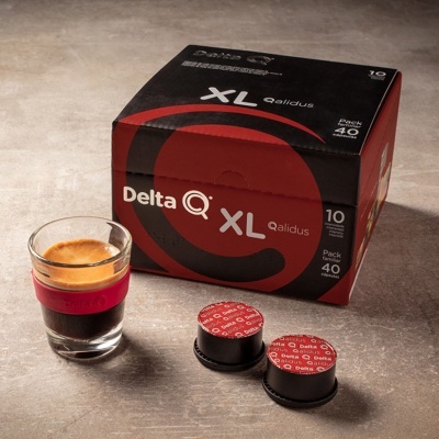 Pacote de cápsulas de café Delta Q XL Qalidus, duas cápsulas e copo com café expresso