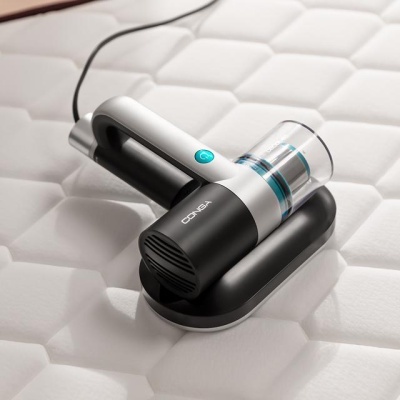 aspirador de pó portátil CONGA em preto e cinzento sobre colchão branco