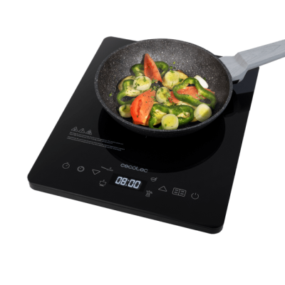 Placa de indução preta Cecotec com frigideira e vegetais frescos