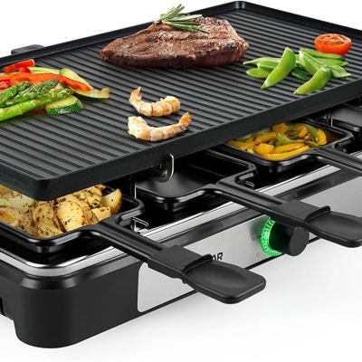 Churrasqueira elétrica com chapa de ferro fundido e frigideiras com comida variada grelhada