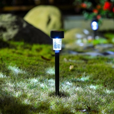 Lâmpada solar de jardim com suporte preto na relva à noite