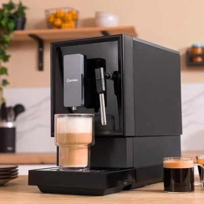 Máquina de café expresso preta Cumbia com copo alto de vidro e chávenas com café