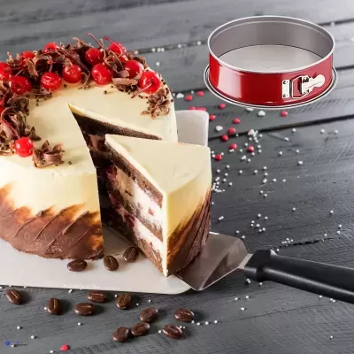 Bolo decorado com cerejas e forma de bolo vermelha ao lado