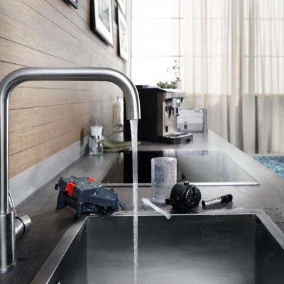 Pia de cozinha moderna com torneira e máquina de café na bancada cinza