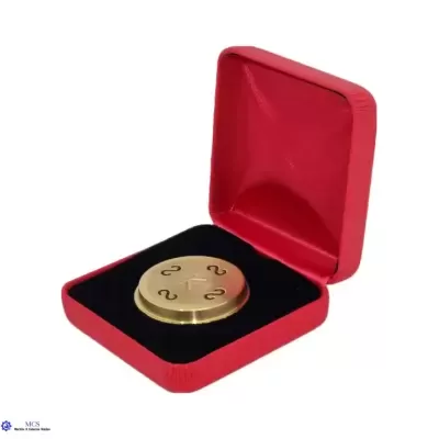 Caixa vermelha aberta com objeto redondo dourado dentro em fundo branco