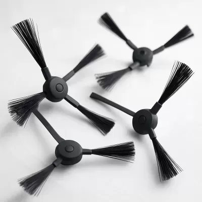 Quatro escovas laterais pretas para aspirador robô sobre fundo branco