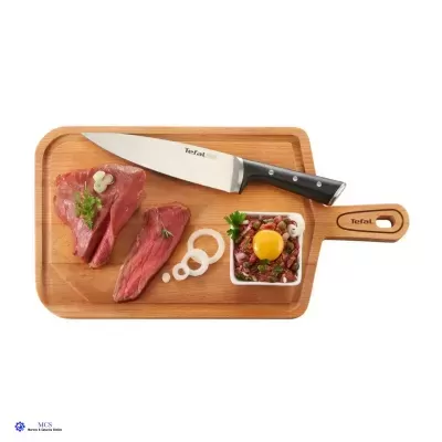 Tábuas de cortar com carne crua, recipiente branco com carne picada e gema de ovo, faca Tefal