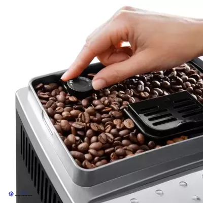 Máquina de café com grãos de café e mão ajustando botão