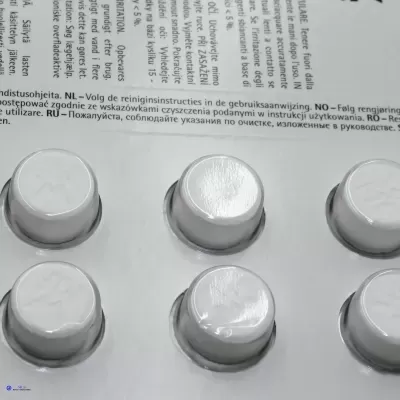 Embalagem branca com comprimidos em blíster prateado e texto multilíngue