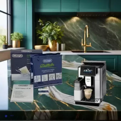 Cafeteira automática DeLonghi com café e caixas de cápsulas numa bancada verde marmoreada