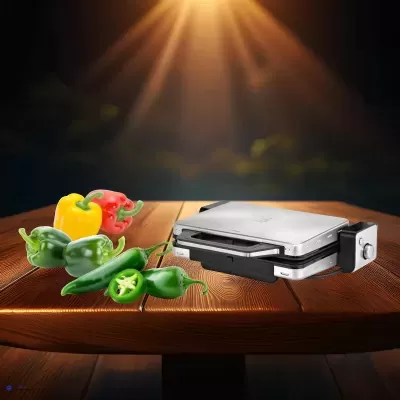 Máquina de sanduíches metálica com pimentos coloridos numa mesa de madeira